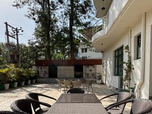an outdoor patio with tables and chairs and a fireplace at 15 Verandah in Dehradun