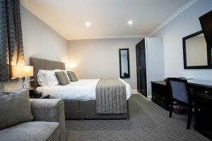 Habitación de hotel con cama y escritorio en New Inn Hotel, en Ellon