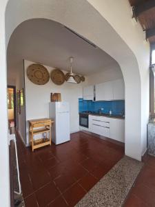 eine Küche mit einem weißen Kühlschrank und einem Tisch in der Unterkunft Casa La Pelosa in Stintino