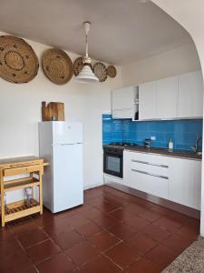 eine Küche mit einem weißen Kühlschrank und einem Tisch in der Unterkunft Casa La Pelosa in Stintino