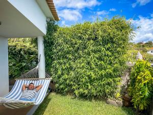 mężczyzna leżący w hamaku na podwórku w obiekcie Indigo Star House w mieście Ribeira Brava