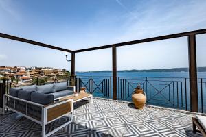 balcone con divano e vista sull'acqua di Villa Chara ad Ammouliani