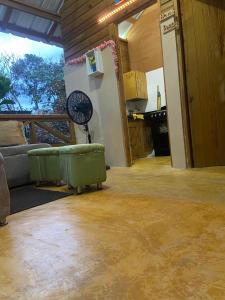 a living room with a couch and a fan at Villa Don Che in Jarabacoa