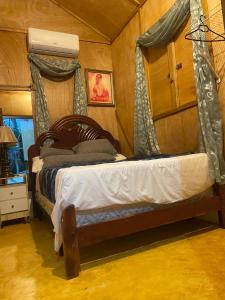 a bedroom with a bed with a canopy at Villa Don Che in Jarabacoa