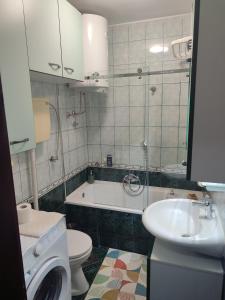 a bathroom with a sink and a toilet and a tub at HushHush Apartman in Belgrade