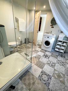 a bathroom with a shower and a washing machine at Dome square apartment, Old Town in Riga