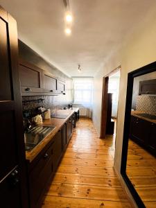 a kitchen with wooden flooring and a large kitchen with a sink at Dome square apartment, Old Town in Riga