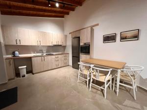 a kitchen with a wooden table and a table and chairs at The Courtyard Episkopi Guest Houses in Episkopi Lemesou