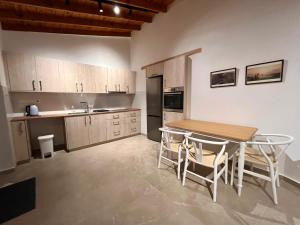 a kitchen with a wooden table and a table and chairs at The Courtyard Episkopi Guest Houses in Episkopi Limassol