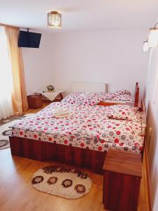 1 dormitorio con 2 camas con colchas rojas y blancas en Pensiunea Dimitrie en Mănăstirea Humorului