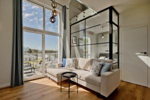 uma sala de estar com um sofá branco e uma grande janela em Porto Mare BlueApart Mechelinki em Mechelinki
