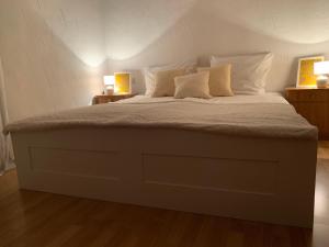 a large bed with white pillows and two lamps at Ferienwohnung Zumhof in Rudersberg
