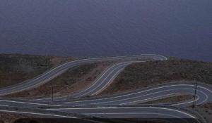 a winding road on the side of a hill with the ocean at house FYNTIKAKH - SKALA in Anopoli Sfakion