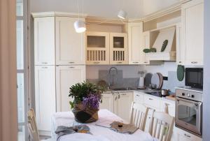 a kitchen with a table with a vase of flowers on it at My Place Your Place in Corniglia