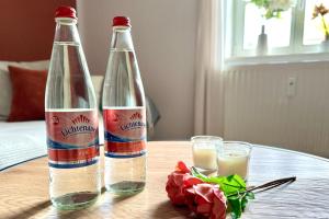 twee flessen op een tafel met glazen melk bij Stilvolles Apartment mit Festungsblick im Zentrum in Königstein an der Elbe