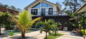 una casa con piscina y palmeras en Tinyhouses and Tropical Gardens, en Zambrano