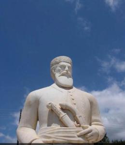 a large statue of a man holding a instrument at house FYNTIKAKH - SKALA in Anopoli Sfakion