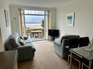 a living room with two couches and a view of the ocean at Southover Beach in Woolacombe