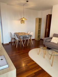 a living room with a table and a couch at V&B VACACIONAL in Suances