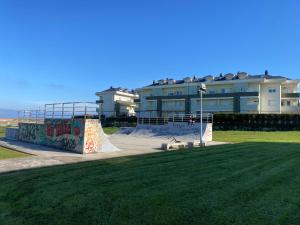 a skate park with a skateboard ramp in front of a building at V&B VACACIONAL in Suances