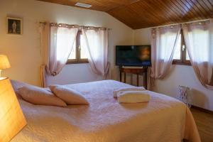 - une chambre avec un lit, une télévision et des fenêtres dans l'établissement Chez Pepette et Serge, à Montdragon