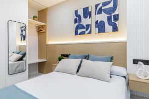 a bedroom with a bed with blue and white pillows at Stay Belonio in Málaga