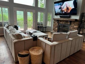 a living room with two couches and a flat screen tv at Luxury Mountain Home in Huntingdon