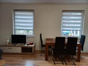 a dining room with a table and two windows at Rose Apartment in Jajce