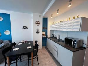 cocina y comedor con mesa y microondas en Green Tea Apartment Warsaw Centrum, en Varsovia