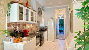 a kitchen with white cabinets and a white refrigerator at Grand Appartement Haussmanien de Standing avec Jacuzzi Terrasse et Parking en Hyper Centre in Bordeaux