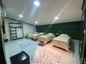 a group of beds in a room with a tv at Pousada Point in Aracati