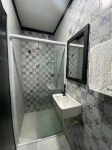 a bathroom with a shower and a sink and a mirror at Pousada Point in Aracati