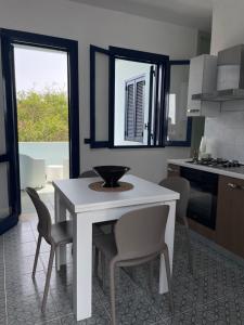 トッレ・デル・オルソにあるCasaBoa 300M Torre dell'Orsoのキッチン(白いテーブル、椅子付) +7枚の写真