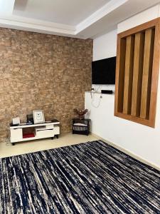 uma sala de estar com um tapete grande e uma parede de tijolos em La Remaz 35 em El Jadida