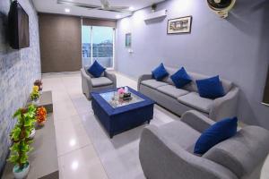 sala de estar con sofás y almohadas azules en Hotel and apartments inn en Lahore