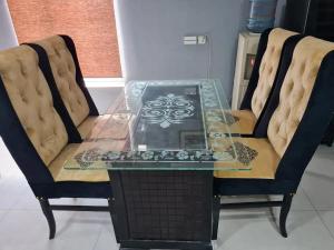 una mesa de cristal con 2 sillas y una tapa de cristal en Hotel and apartments inn en Lahore