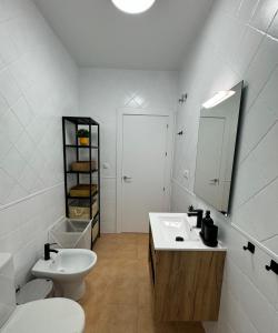 a white bathroom with a sink and a toilet at Apartamentos El Llano Málaga 7 in Sorbas