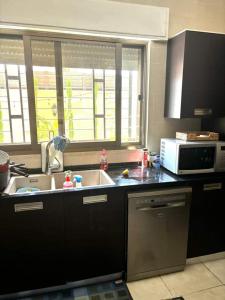 a kitchen with a sink and a microwave at Maan 12 in Ma‘ān