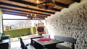 a dining room with two tables and a stone wall at Guest House Saint George in Vukovo