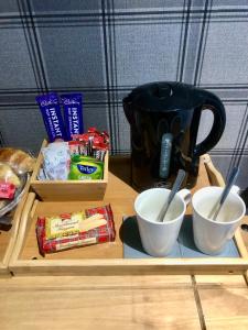 a wooden tray with two cups and a coffee maker at MacArthur House NC500 in Wick