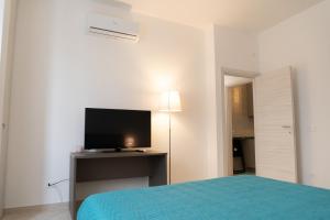 a bedroom with a bed and a television on a desk at B&B Cateum in Andria