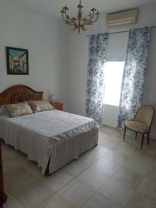 1 dormitorio con 1 cama, 1 silla y 1 ventana en Chalet Mojácar Mícar 41, en Mojácar