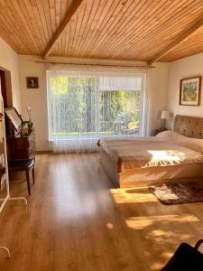 a bedroom with a large bed and a window at Perfectly located summerhouse in Druskininkai
