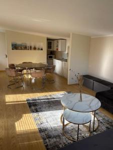 a living room with a table and chairs and a kitchen at Perfectly located summerhouse in Druskininkai +18 photos