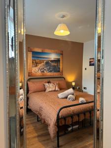 ウィットリー・ベイにあるSpanish City View 3 Stunning sea front apartment Free onsite parkingの壁に絵が飾られたベッドのある寝室