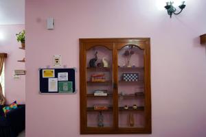 a wooden cabinet in a room with a wall at The Nerd Nest Kolkata in Kolkata