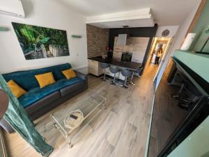 a living room with a blue couch and a table at Votre résidence de vacances avec piscine, tennis, à 2 minutes de la mer in Vallauris