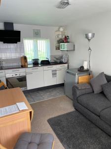 a living room with a couch and a kitchen at Leylands Annexe in East Harptree