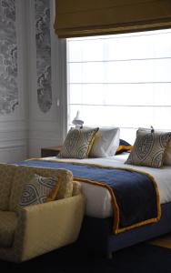sypialnia z 2 łóżkami, oknem i kanapą w obiekcie Smartflats - Raphael Suites w Antwerpii