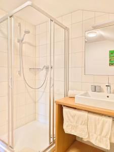 uma casa de banho com um chuveiro e um lavatório. em Pension Zita em Schoppernau